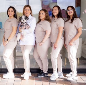 Dr. Roman and her team posing together in front of the office